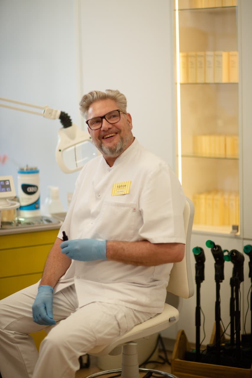 Peter Boeters, oprichter van tiptoe, lachend in de salon in zijn witte jas