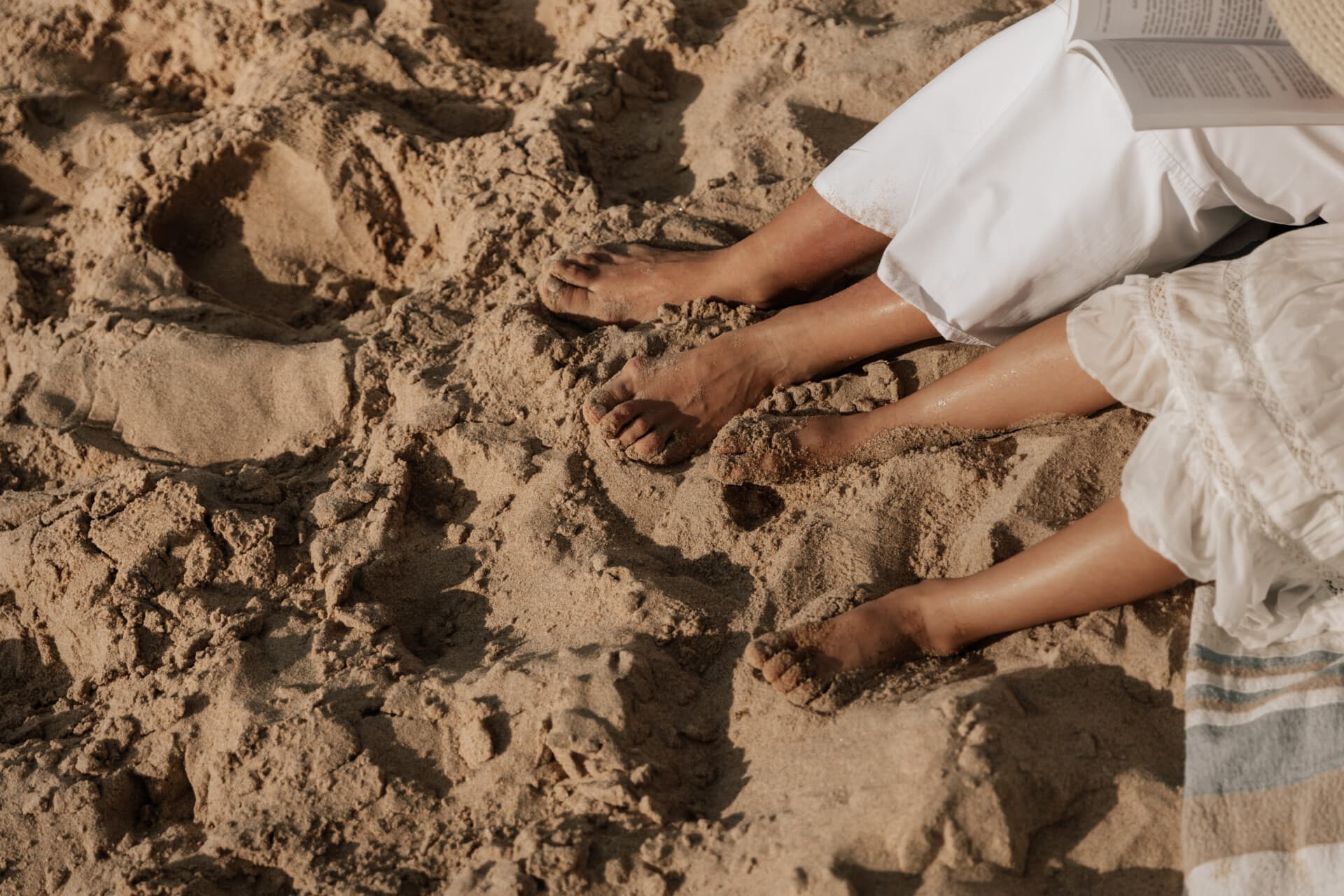 Blote voeten met gezonde, verzorgde nagels op het strand na een kalknagelbehandeling bij tiptoe