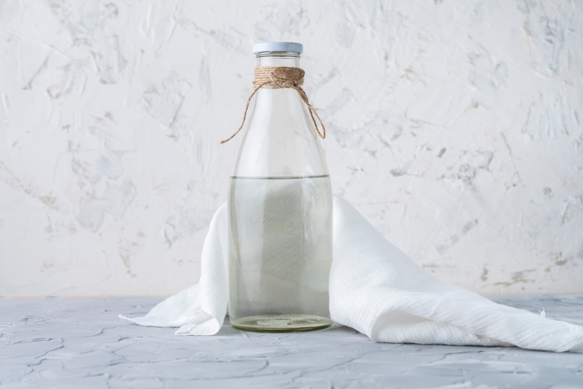 Glazen fles met heldere vloeistof — azijn tegen schimmelnagels